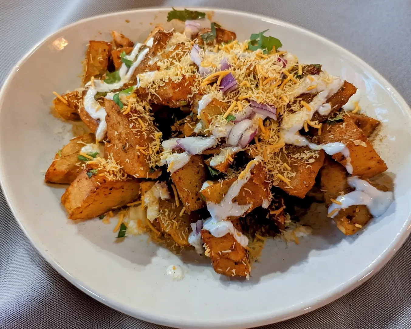 Aloo Tikki Chaat — Golden potato patties topped with chickpeas, tangy chutneys,
