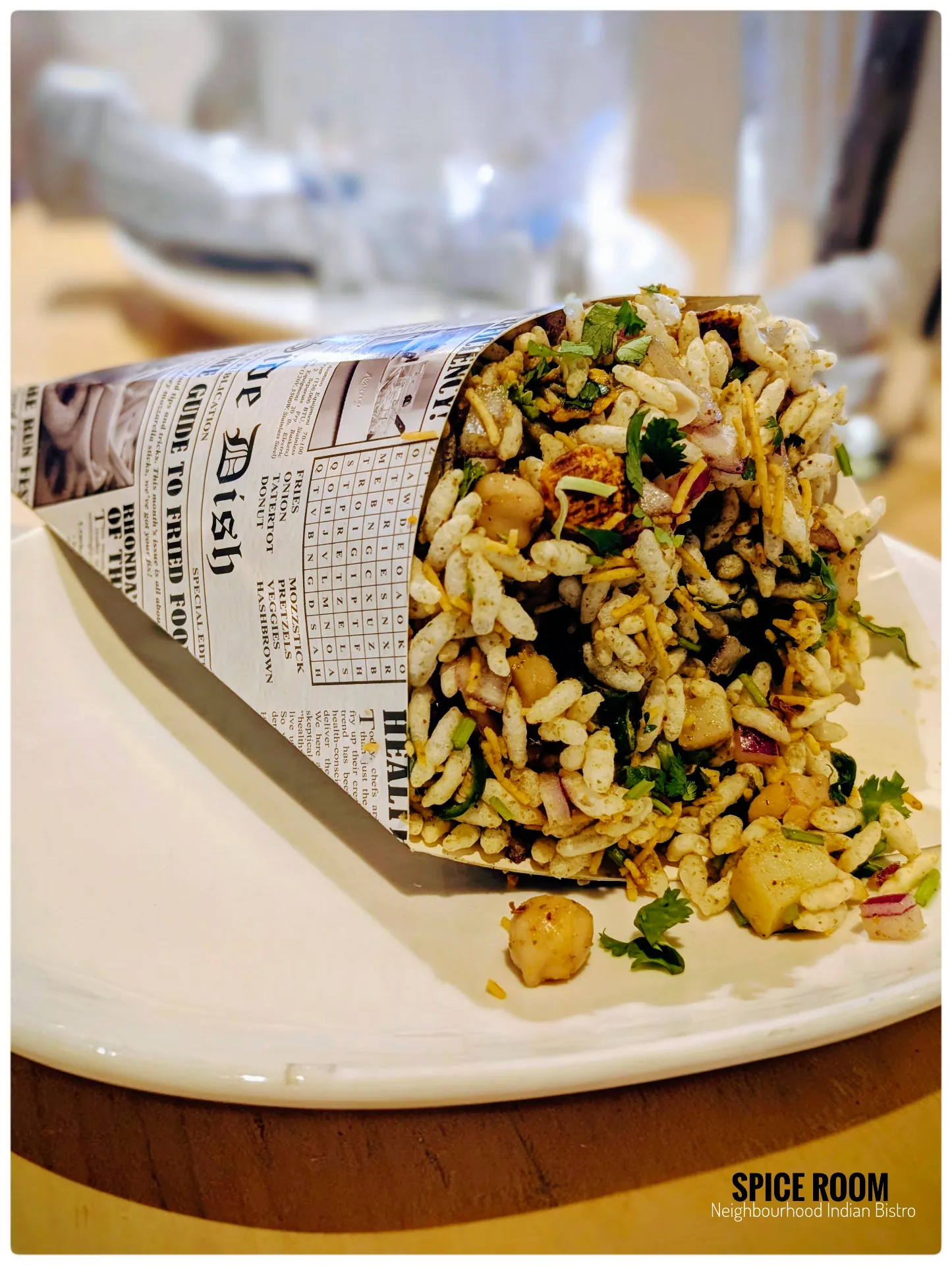 A bowl of a classic Indian street food, Bombay bhel, a savory snack with puffed rice, veggies, and chaat | SPICE ROOM Denver