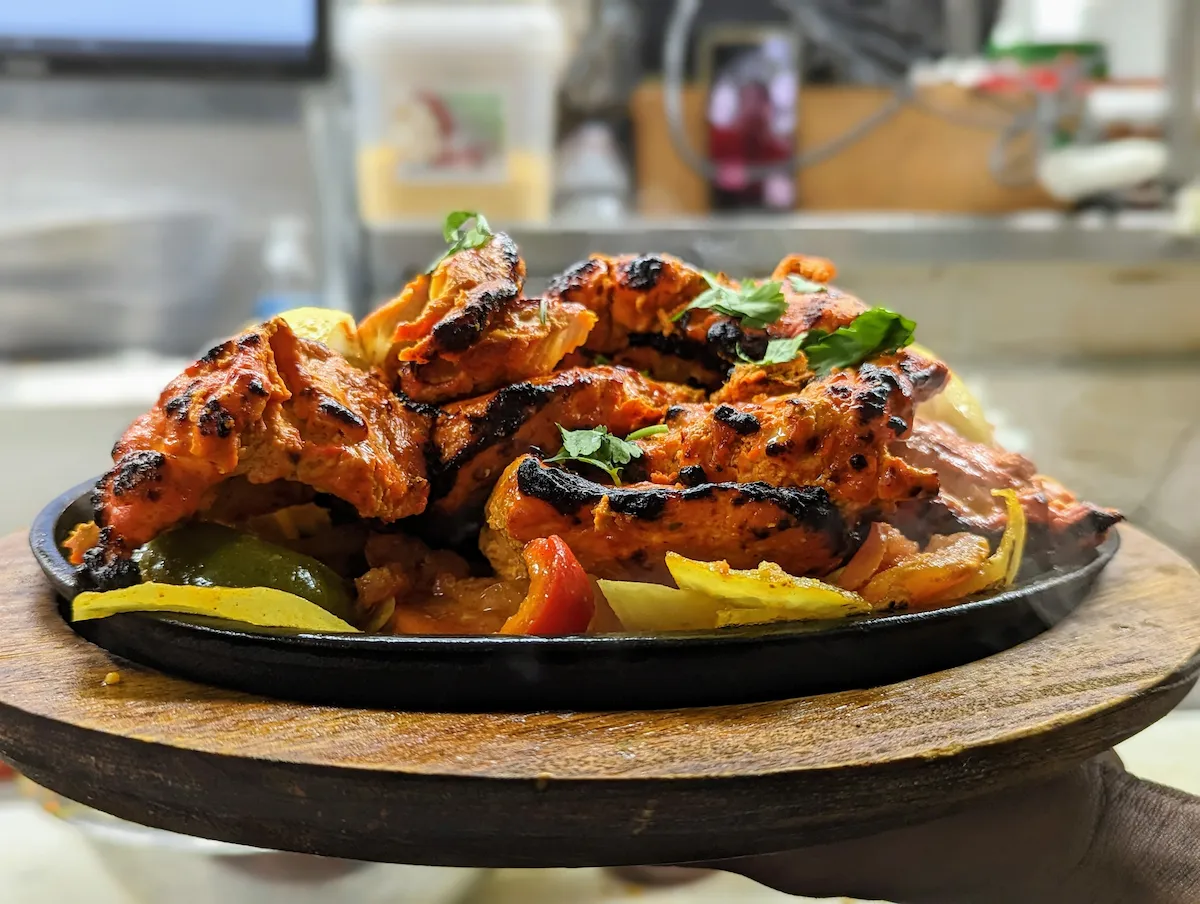 Chicken Tandoori Sizzler – Marinated chicken pieces cooked in the clay oven, served on a sizzling iron plate | SPICE ROOM Denver
