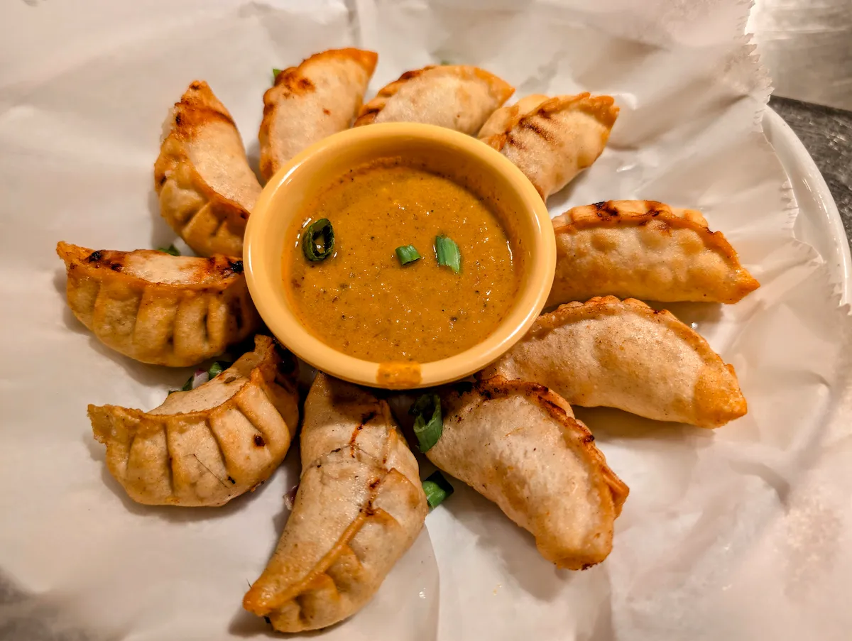 Kothey Momo – Pan-fried Himalayan dumplings arranged with our signature spiced achar sauce | SPICE ROOM Denver