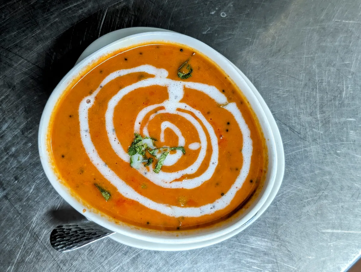 Tomato Soup – South Indian-style spiced tomato soup finished with a swirl of cream and fresh cilantro | SPICE ROOM Denver
