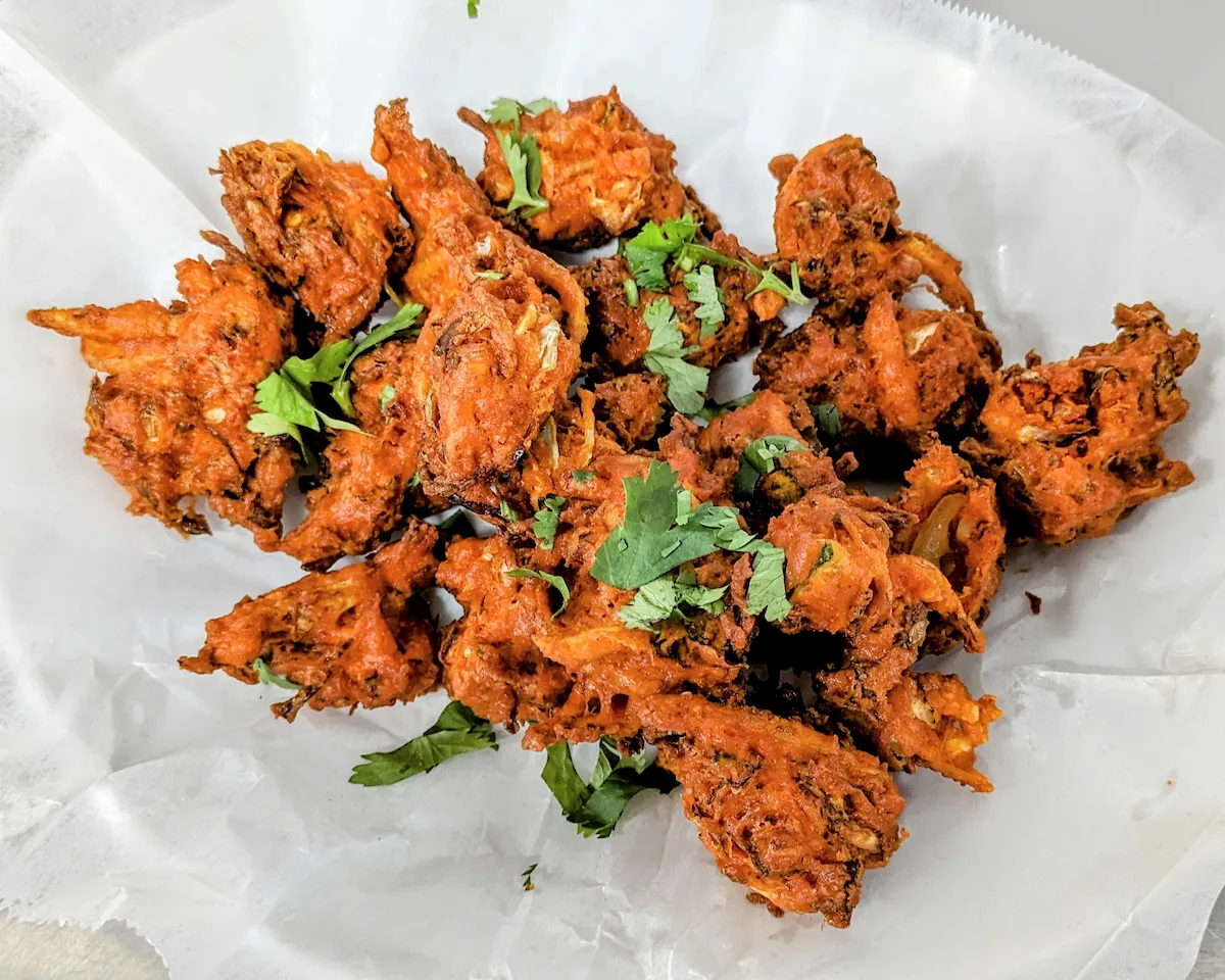 Onion Bhaji – Crispy fried onion fritters seasoned with green chili and fresh cilantro | SPICE ROOM Denver