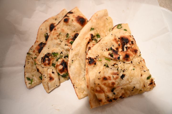 Garlic Cheese Naan – The ultimate naan — stuffed with melted cheese and topped with roasted garlic. B | SPICE ROOM Denver